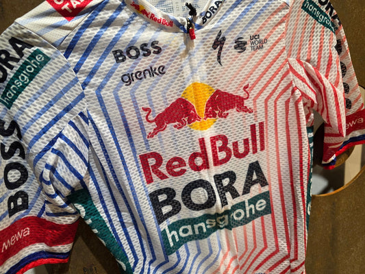 Kurzarm Trikot - BOH von Specialized, SPECIALIZED RED BULL - BORA HANSGROHE LIGHTWEIGHT JERSEY SS TDF / ROGLIC vor USEDBIKES - OB.DE Hintergrund
