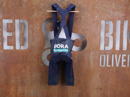 Hosen - BOH von Specialized, SPECIALIZED RED BULL - BORA HANSGROHE RACE BIB SHORT / KURZE TRÄGERHOSE vor USEDBIKES - OB.DE Hintergrund