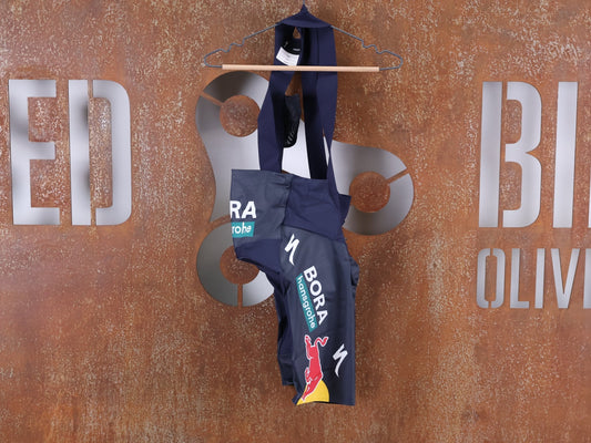 Hosen - BOH von Specialized, SPECIALIZED RED BULL - BORA HANSGROHE RACE BIB SHORT LEADER / KURZE TRÄGERHOSE vor USEDBIKES - OB.DE Hintergrund