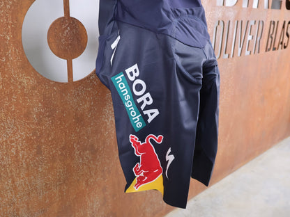 Hosen - BOH von Specialized, SPECIALIZED RED BULL - BORA HANSGROHE RACE BIB SHORT LEADER / KURZE TRÄGERHOSE vor USEDBIKES - OB.DE Hintergrund