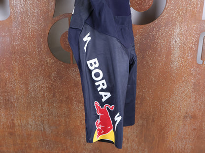 Hosen - BOH von Specialized, SPECIALIZED RED BULL - BORA HANSGROHE RACE BIB SHORT LONG / KURZE TRÄGERHOSE vor USEDBIKES - OB.DE Hintergrund