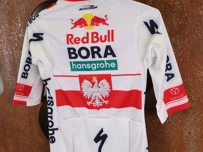 Kurzarm Trikot - BOH von Specialized, SPECIALIZED RED BULL - BORA HANSGROHE RACE JERSEY SS / POLAND CHAMPION vor USEDBIKES - OB.DE Hintergrund