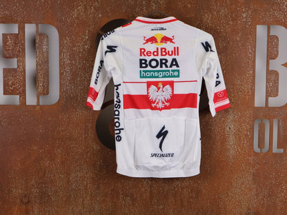 Kurzarm Trikot - BOH von Specialized, SPECIALIZED RED BULL - BORA HANSGROHE RACE JERSEY SS / POLAND CHAMPION vor USEDBIKES - OB.DE Hintergrund