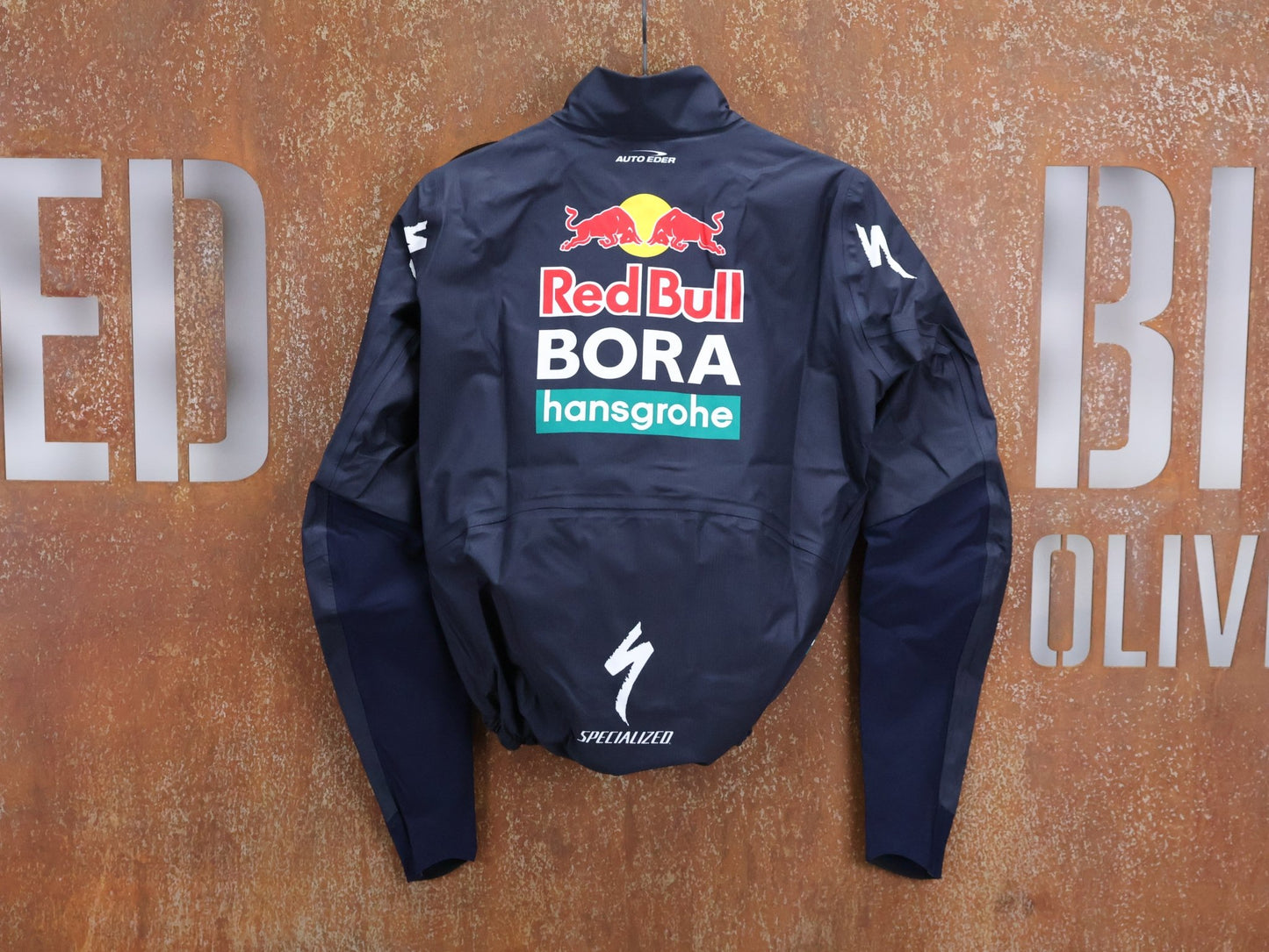 Regenbekleidung - BOH von Specialized, SPECIALIZED RED BULL - BORA HANSGROHE RAIN JACKET / WASSERDICHTE PRO TEAM REGENJACKE vor USEDBIKES - OB.DE Hintergrund