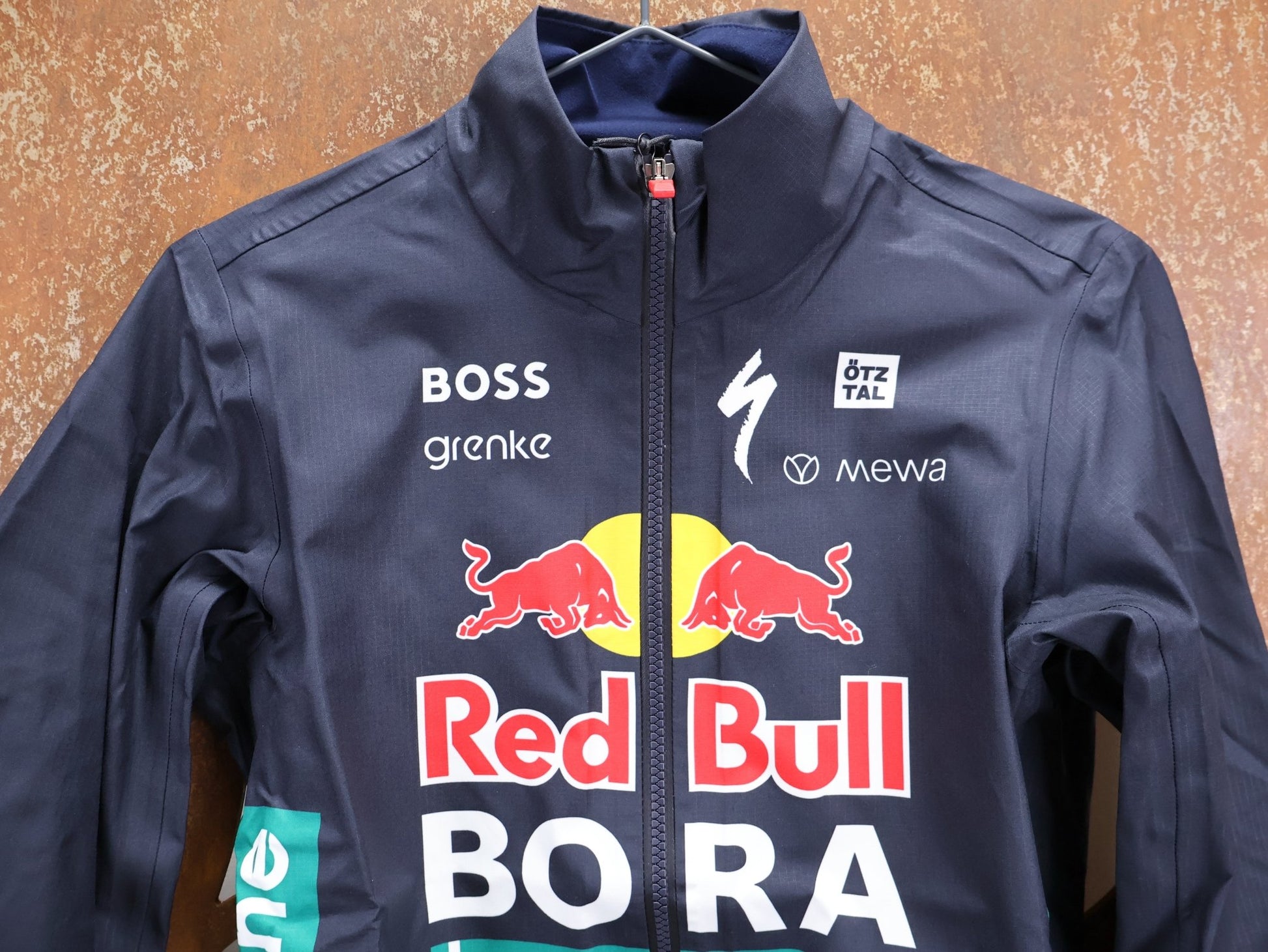 Regenbekleidung - BOH von Specialized, SPECIALIZED RED BULL - BORA HANSGROHE RAIN JACKET / WASSERDICHTE PRO TEAM REGENJACKE vor USEDBIKES - OB.DE Hintergrund