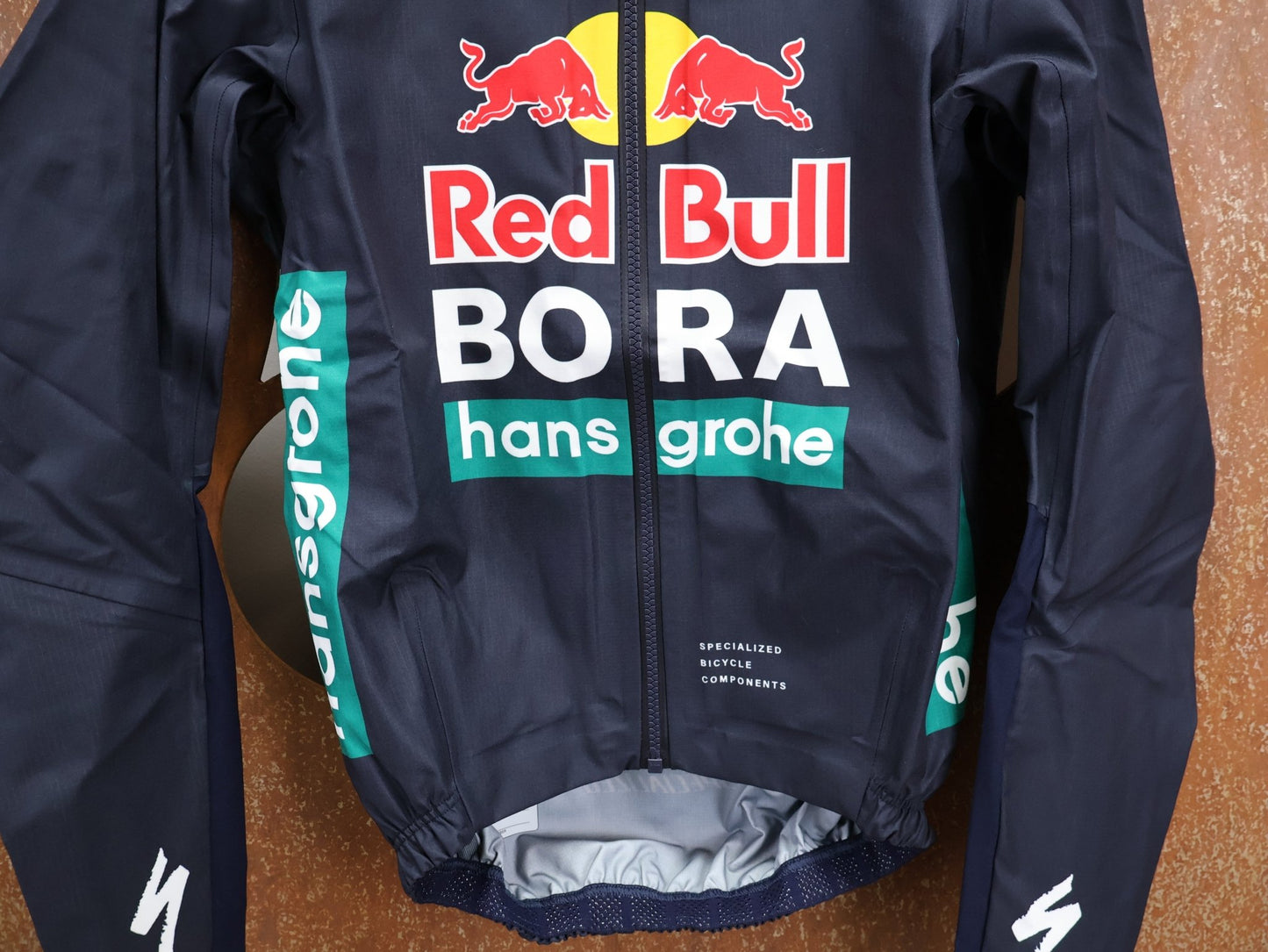 Regenbekleidung - BOH von Specialized, SPECIALIZED RED BULL - BORA HANSGROHE RAIN JACKET / WASSERDICHTE PRO TEAM REGENJACKE vor USEDBIKES - OB.DE Hintergrund