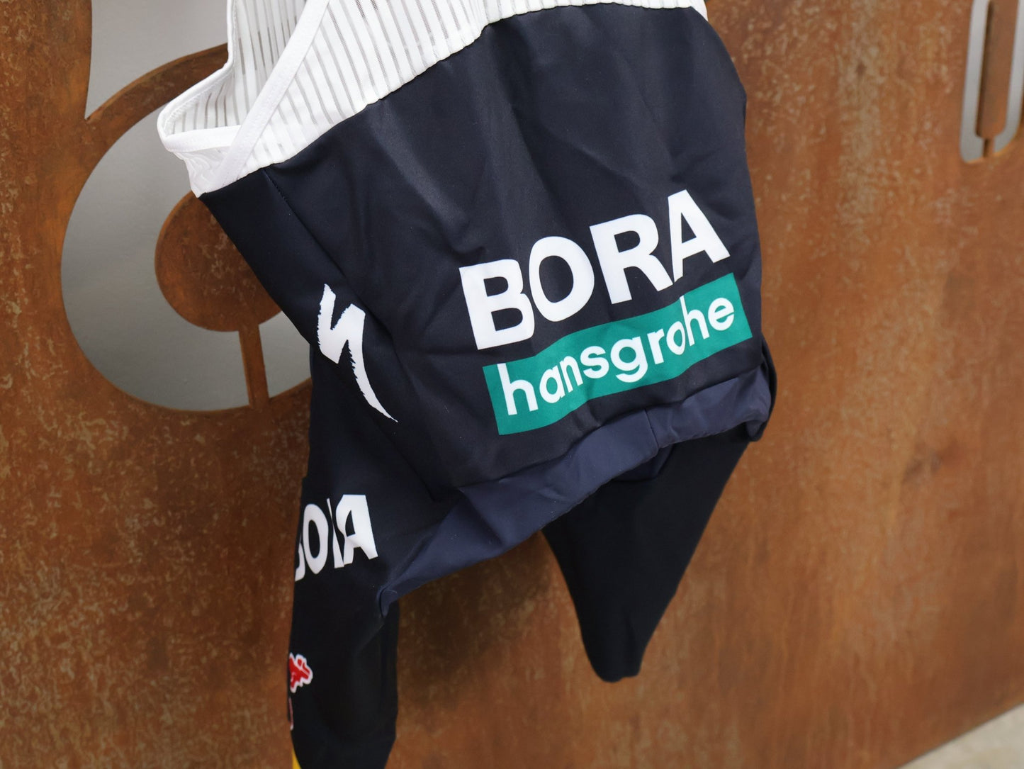 Hosen - BOH von Specialized, SPECIALIZED RED BULL - BORA HANSGROHE REPLICA BIB SHORT / KURZE TRÄGERHOSE vor USEDBIKES - OB.DE Hintergrund