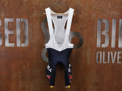 Hosen - BOH von Specialized, SPECIALIZED RED BULL - BORA HANSGROHE REPLICA BIB SHORT / KURZE TRÄGERHOSE vor USEDBIKES - OB.DE Hintergrund