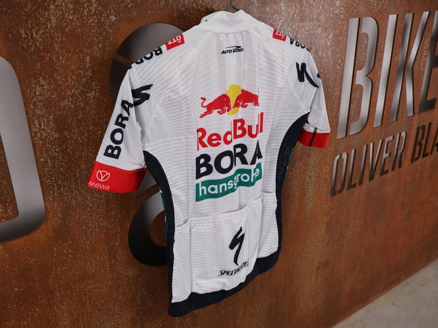Kurzarm Trikot - BOH von Specialized, SPECIALIZED RED BULL - BORA HANSGROHE REPLICA JERSEY SS / KURZARM TRIKOT U23 vor USEDBIKES - OB.DE Hintergrund