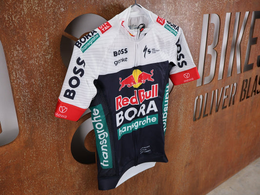 Kurzarm Trikot - BOH von Specialized, SPECIALIZED RED BULL - BORA HANSGROHE REPLICA JERSEY SS / KURZARM TRIKOT U23 vor USEDBIKES - OB.DE Hintergrund