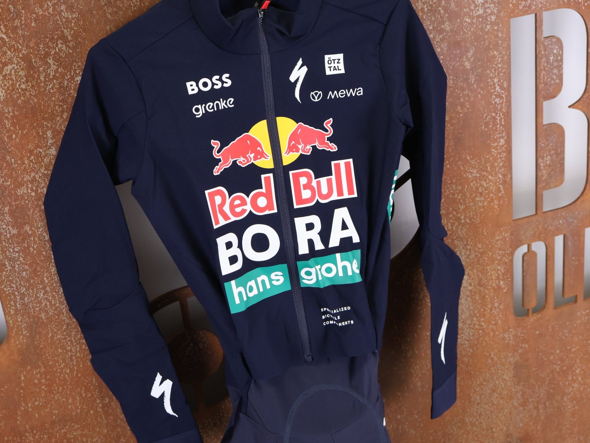 Anzug - BOH von Specialized, SPECIALIZED RED BULL - BORA HANSGROHE WET WEATHER SKIN SUIT / EINTEILER vor USEDBIKES - OB.DE Hintergrund