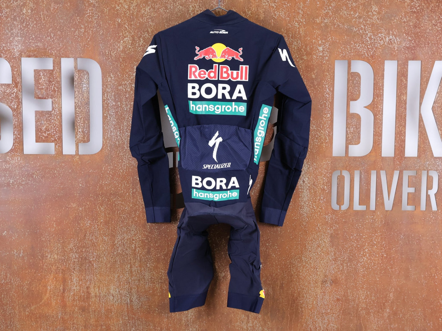 Anzug - BOH von Specialized, SPECIALIZED RED BULL - BORA HANSGROHE WET WEATHER SKIN SUIT / EINTEILER vor USEDBIKES - OB.DE Hintergrund