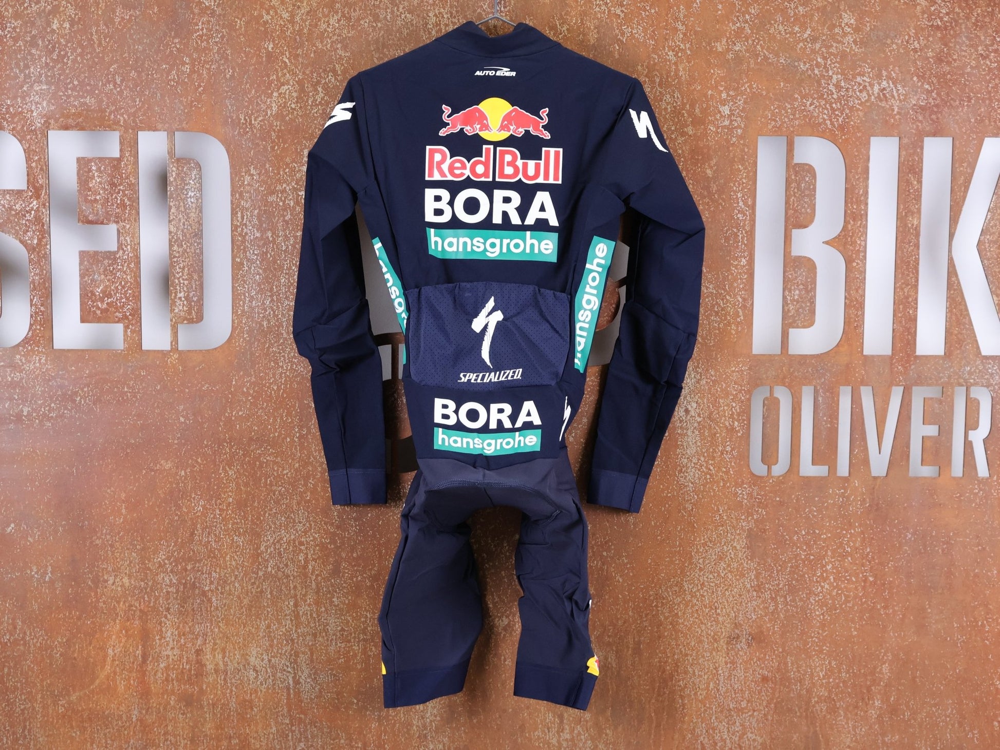 Anzug - BOH von Specialized, SPECIALIZED RED BULL - BORA HANSGROHE WET WEATHER SKIN SUIT / EINTEILER vor USEDBIKES - OB.DE Hintergrund