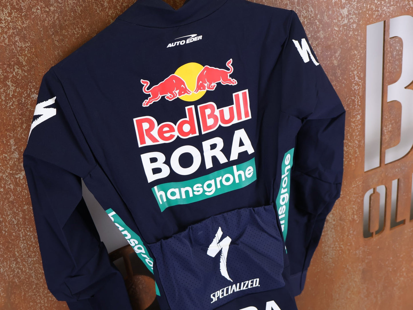 Anzug - BOH von Specialized, SPECIALIZED RED BULL - BORA HANSGROHE WET WEATHER SKIN SUIT / EINTEILER vor USEDBIKES - OB.DE Hintergrund