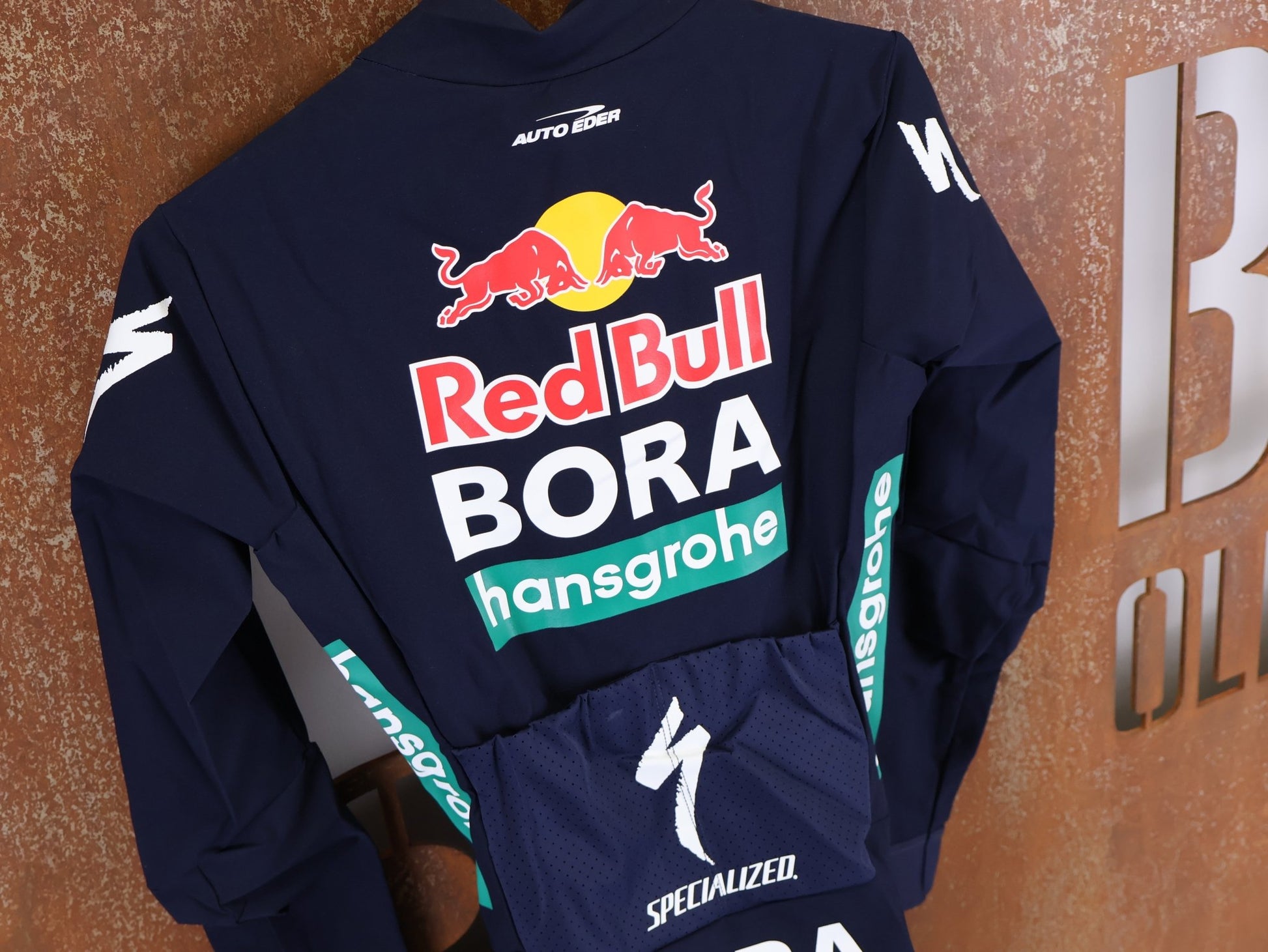 Anzug - BOH von Specialized, SPECIALIZED RED BULL - BORA HANSGROHE WET WEATHER SKIN SUIT / EINTEILER vor USEDBIKES - OB.DE Hintergrund