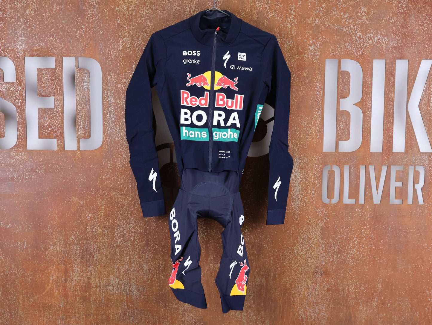Anzug - BOH von Specialized, SPECIALIZED RED BULL - BORA HANSGROHE WET WEATHER SKIN SUIT / EINTEILER vor USEDBIKES - OB.DE Hintergrund