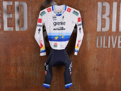 Anzug - BOH von Specialized, SPECIALIZED TGA ROOKIES OF RED BULL - BORA HANSGROHE AERO SKIN SUIT LS / EUROPEAN CHAMPION vor USEDBIKES - OB.DE Hintergrund