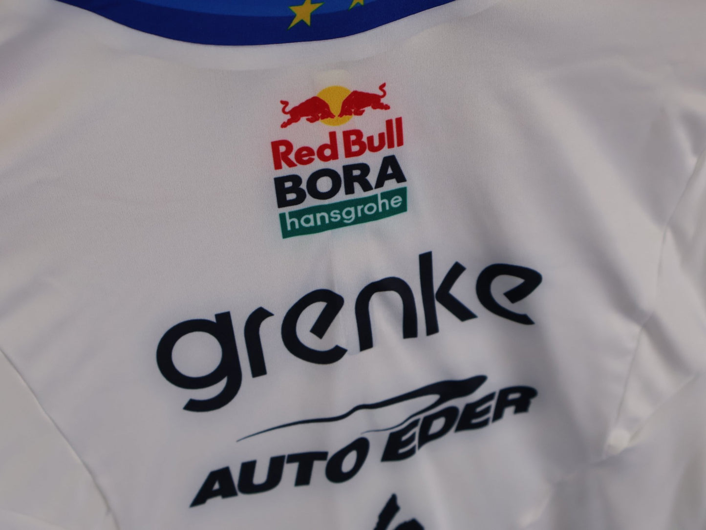 Anzug - BOH von Specialized, SPECIALIZED TGA ROOKIES OF RED BULL - BORA HANSGROHE AERO SKIN SUIT LS / EUROPEAN CHAMPION vor USEDBIKES - OB.DE Hintergrund