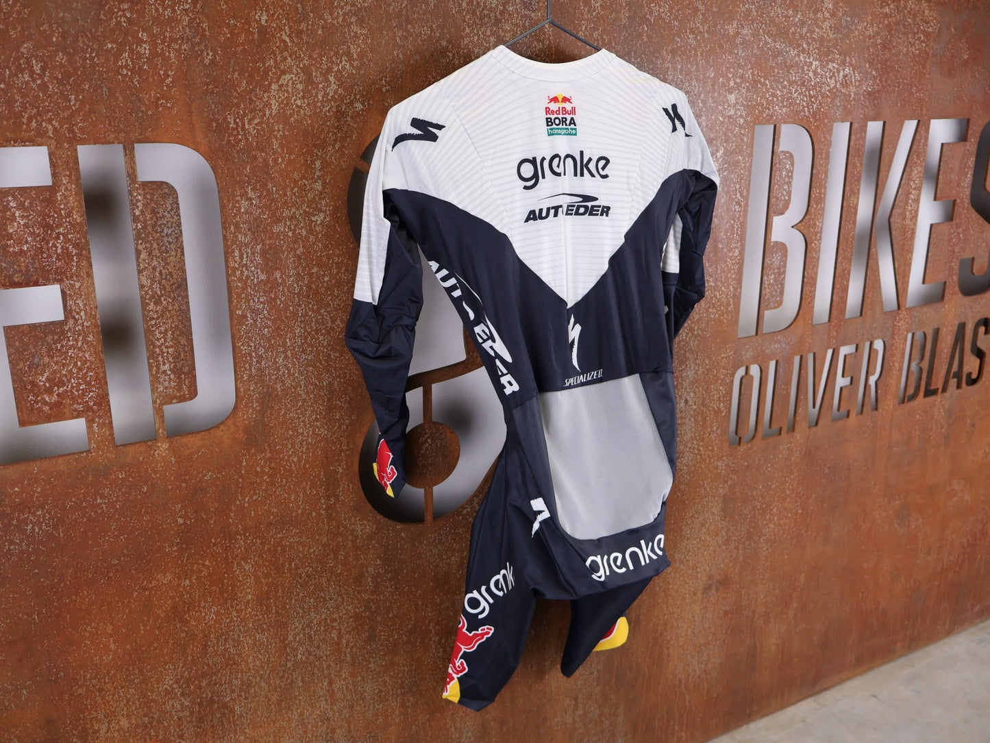 Anzug - BOH von Specialized, SPECIALIZED TGA ROOKIES OF RED BULL - BORA HANSGROHE AERO SKIN SUIT LS / LANGARM EINTEILER vor USEDBIKES - OB.DE Hintergrund