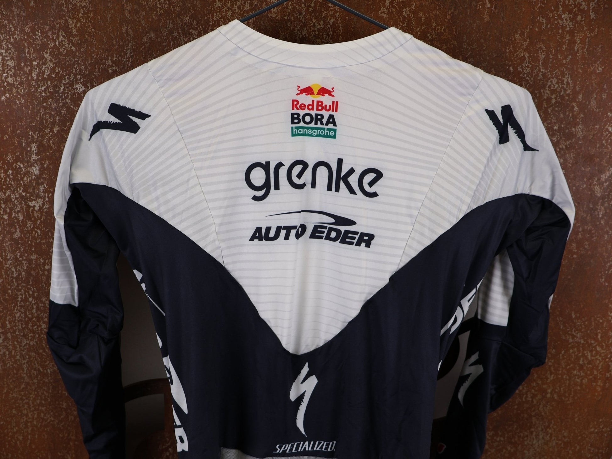 Anzug - BOH von Specialized, SPECIALIZED TGA ROOKIES OF RED BULL - BORA HANSGROHE AERO SKIN SUIT LS / LANGARM EINTEILER vor USEDBIKES - OB.DE Hintergrund