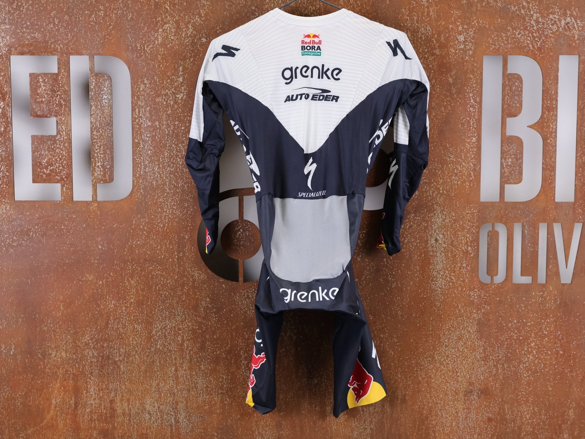 Anzug - BOH von Specialized, SPECIALIZED TGA ROOKIES OF RED BULL - BORA HANSGROHE AERO SKIN SUIT LS / LANGARM EINTEILER vor USEDBIKES - OB.DE Hintergrund