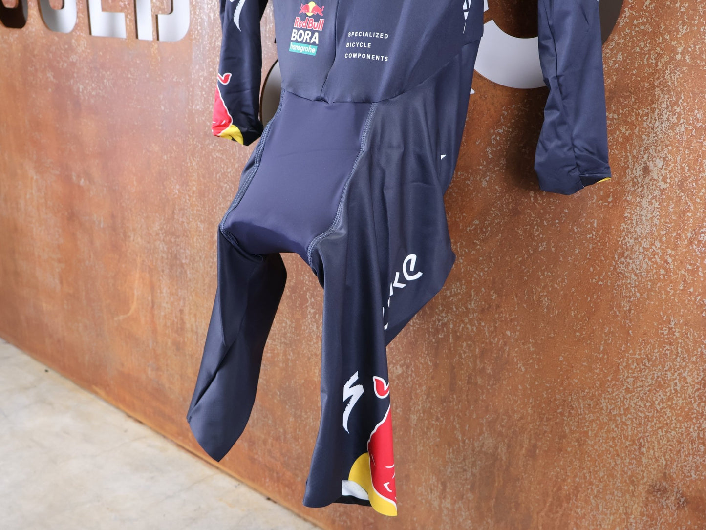 Anzug - BOH von Specialized, SPECIALIZED TGA ROOKIES OF RED BULL - BORA HANSGROHE AERO SKIN SUIT LS / LANGARM EINTEILER vor USEDBIKES - OB.DE Hintergrund