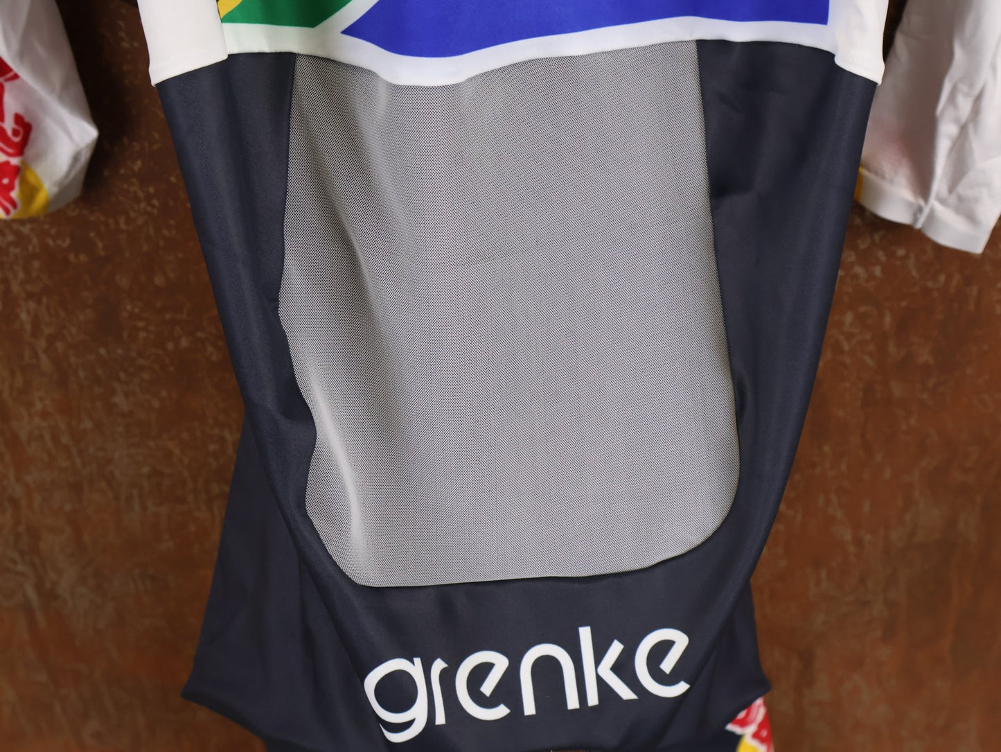 Anzug - BOH von Specialized, SPECIALIZED TGA ROOKIES OF RED BULL - BORA HANSGROHE AERO SKIN SUIT LS / SOUTH AFRICA CHAMPION vor USEDBIKES - OB.DE Hintergrund