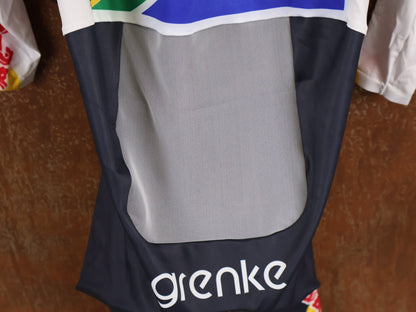 Anzug - BOH von Specialized, SPECIALIZED TGA ROOKIES OF RED BULL - BORA HANSGROHE AERO SKIN SUIT LS / SOUTH AFRICA CHAMPION vor USEDBIKES - OB.DE Hintergrund