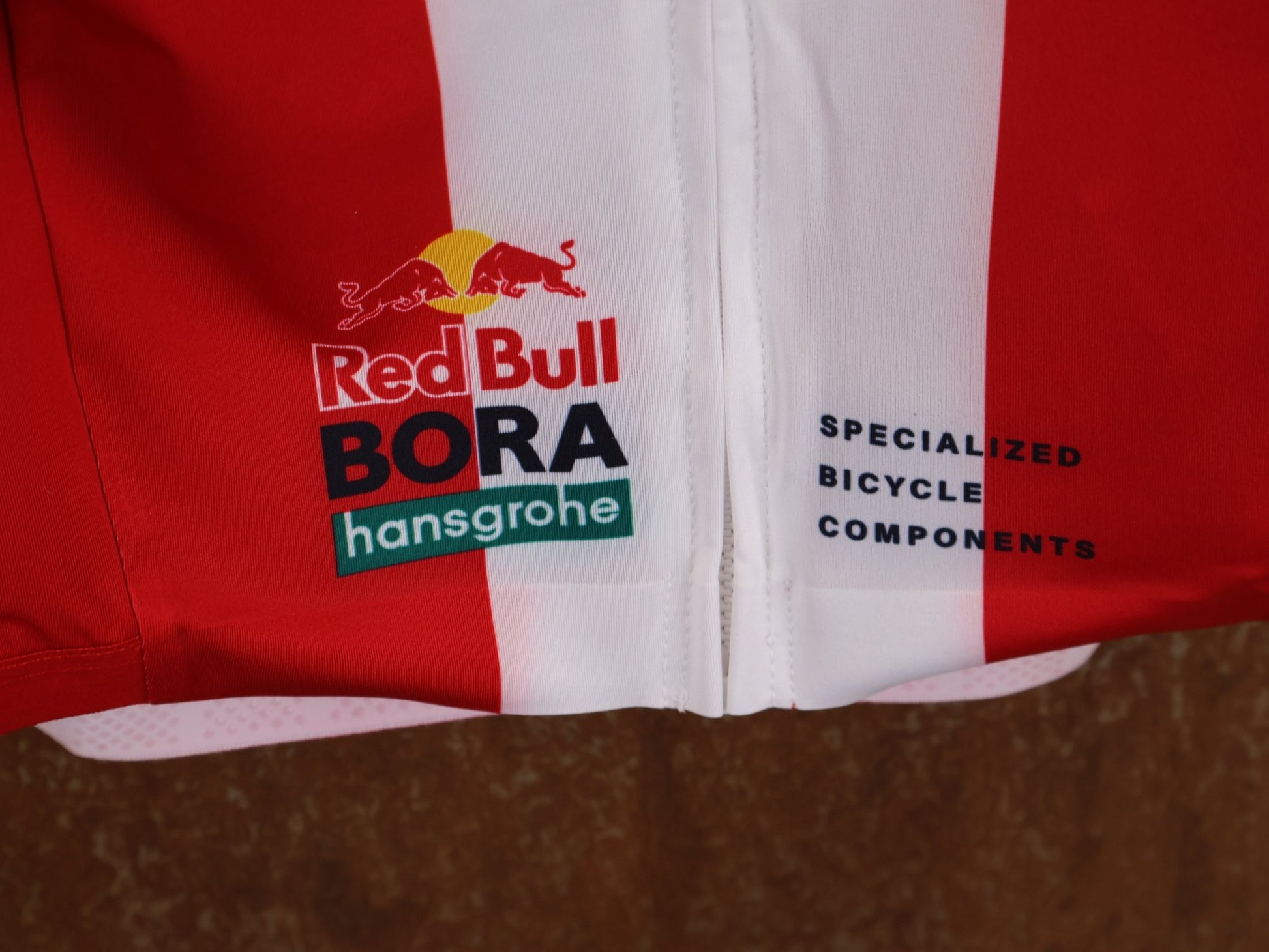 Kurzarm Trikot - BOH von Specialized, SPECIALIZED TGA ROOKIES OF RED BULL - BORA HANSGROHE RACE JERSEY SS / DANISH CHAMPION vor USEDBIKES - OB.DE Hintergrund