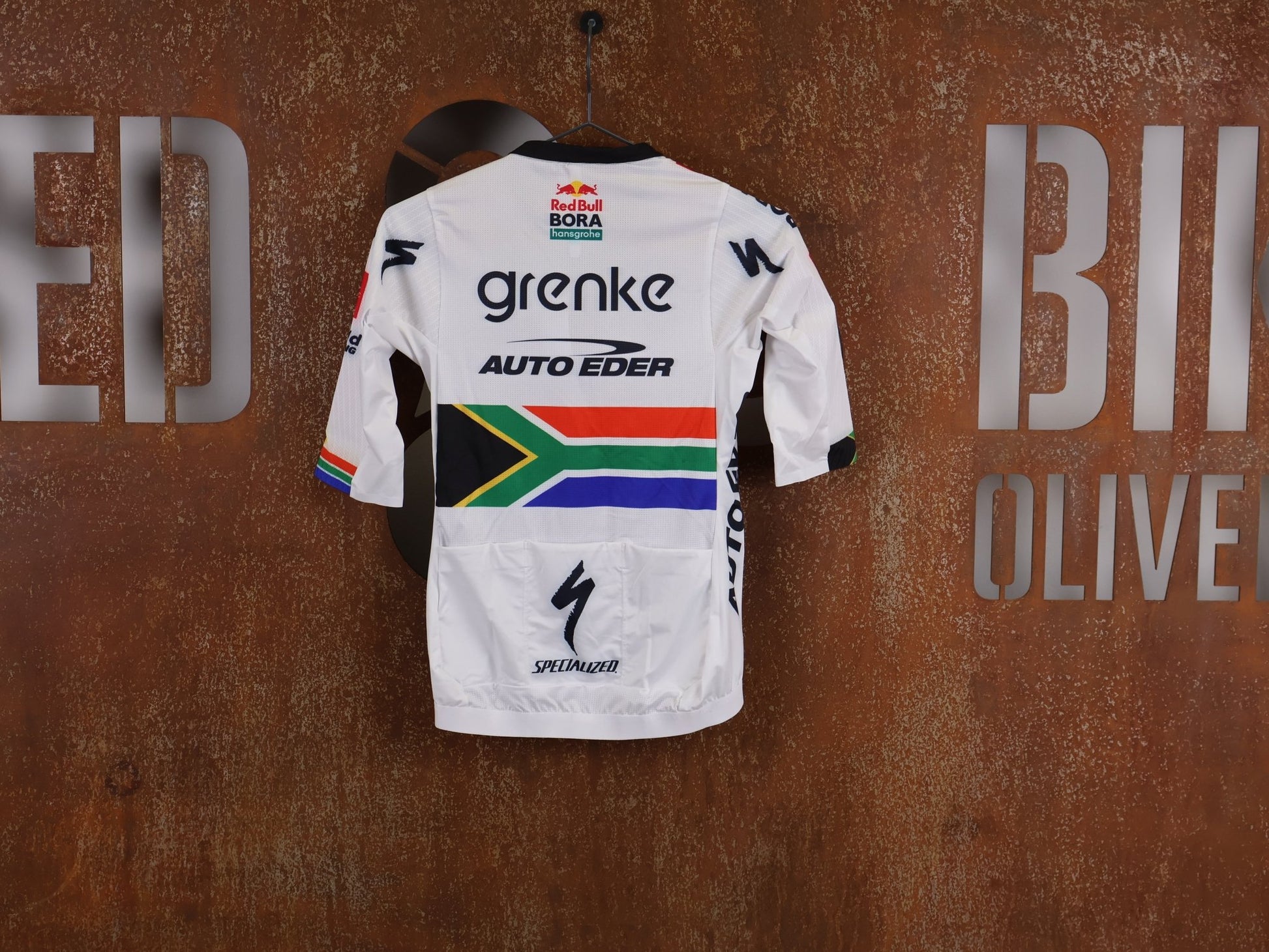Kurzarm Trikot - BOH von Specialized, SPECIALIZED TGA ROOKIES OF RED BULL - BORA HANSGROHE RACE JERSEY SS / SOUTH AFRICA CHAMPION vor USEDBIKES - OB.DE Hintergrund