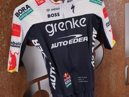 Anzug - BOH von Specialized, SPECIALIZED TGA ROOKIES OF RED BULL - BORA HANSGROHE ROAD SKIN SUIT SS / EINTEILER KURZ vor USEDBIKES - OB.DE Hintergrund