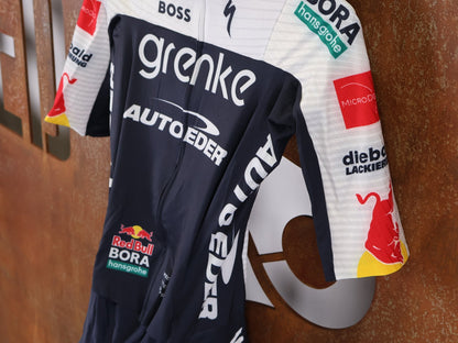 Anzug - BOH von Specialized, SPECIALIZED TGA ROOKIES OF RED BULL - BORA HANSGROHE ROAD SKIN SUIT SS / EINTEILER KURZ vor USEDBIKES - OB.DE Hintergrund