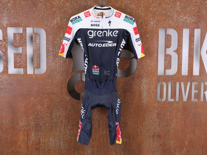 Anzug - BOH von Specialized, SPECIALIZED TGA ROOKIES OF RED BULL - BORA HANSGROHE ROAD SKIN SUIT SS / EINTEILER KURZ vor USEDBIKES - OB.DE Hintergrund