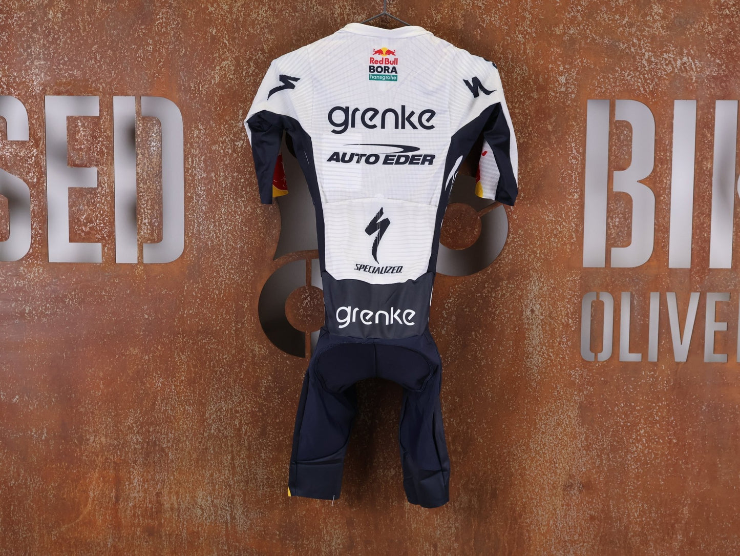 Anzug - BOH von Specialized, SPECIALIZED TGA ROOKIES OF RED BULL - BORA HANSGROHE ROAD SKIN SUIT SS / EINTEILER KURZ vor USEDBIKES - OB.DE Hintergrund