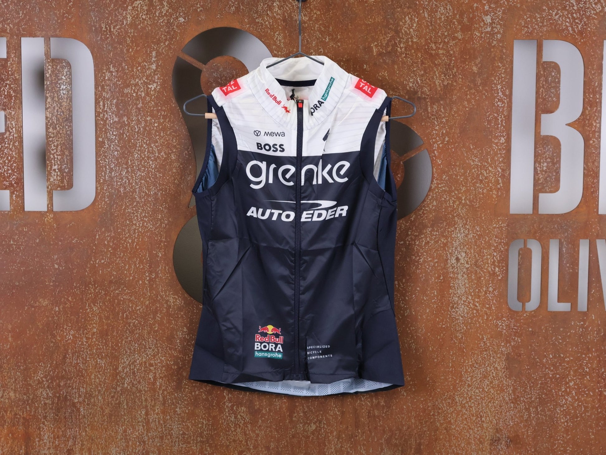 Westen - BOH von Specialized, SPECIALIZED TGA ROOKIES OF RED BULL - BORA HANSGROHE WIND VEST / WESTE vor USEDBIKES - OB.DE Hintergrund