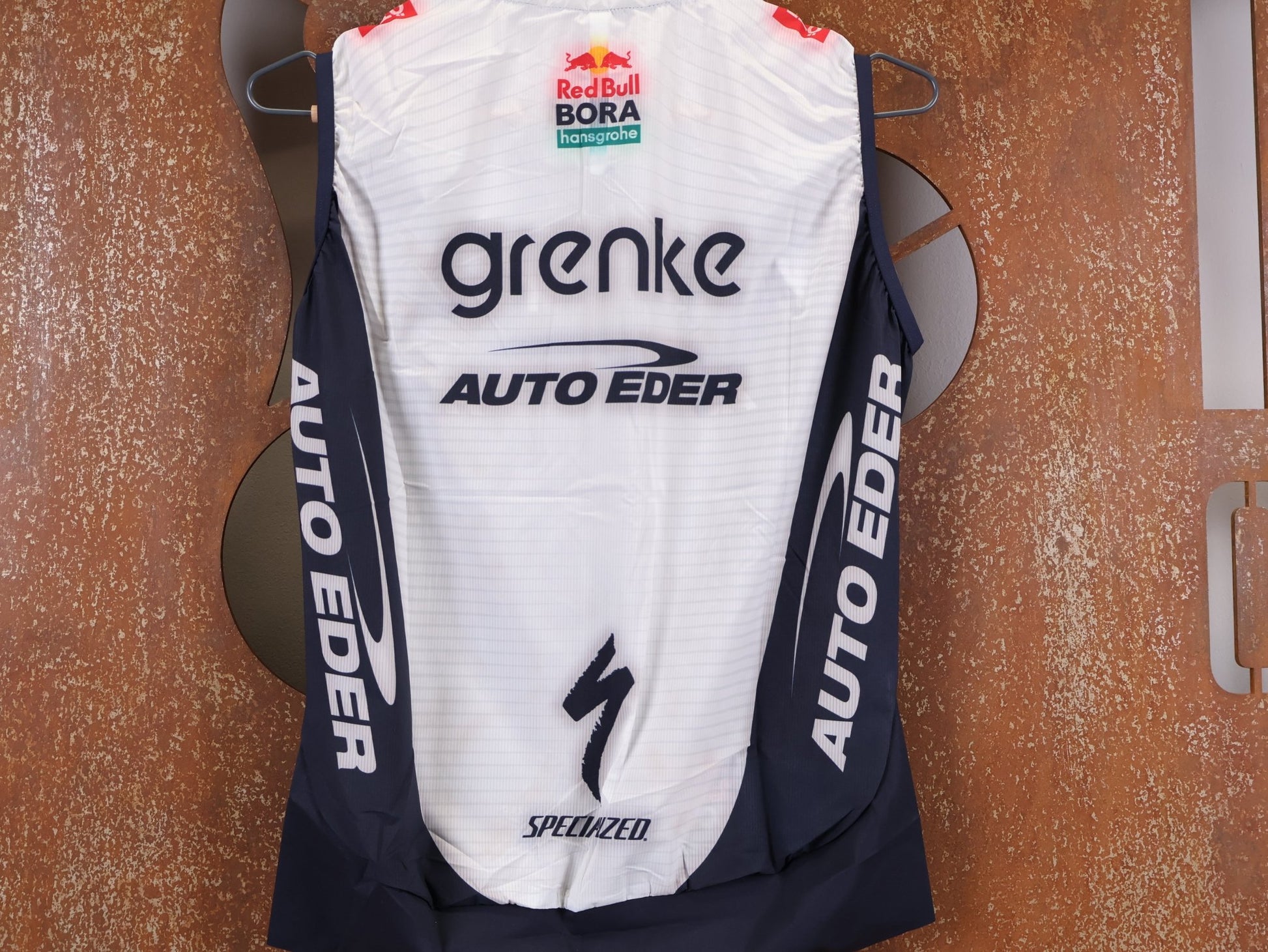 Westen - BOH von Specialized, SPECIALIZED TGA ROOKIES OF RED BULL - BORA HANSGROHE WIND VEST / WESTE vor USEDBIKES - OB.DE Hintergrund