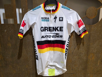 Kurzarm Trikot - U19 von Sportful, SPORTFUL GRENKE - AUTO EDER BOMBER JERSEY / KURZARM TRIKOT / DEUTSCHER MEISTER in variant_title vor USEDBIKES - OB.DE Hintergrund