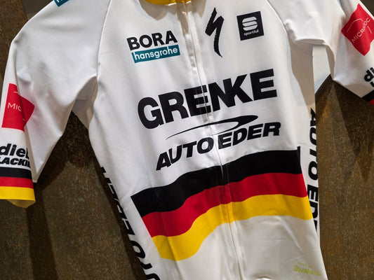 Kurzarm Trikot - U19 von Sportful, SPORTFUL GRENKE - AUTO EDER BOMBER JERSEY / KURZARM TRIKOT / DEUTSCHER MEISTER in variant_title vor USEDBIKES - OB.DE Hintergrund