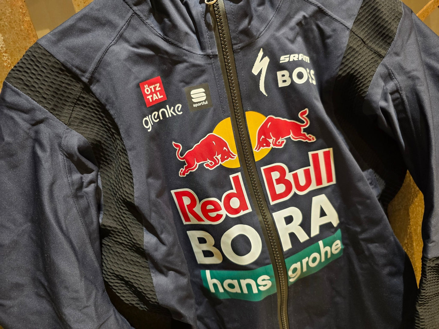 Regenbekleidung - BOH von Sportful, SPORTFUL RED BULL - BORA HANSGROHE BOH AQUA PRO JACKET / REGEN JACKE vor USEDBIKES - OB.DE Hintergrund