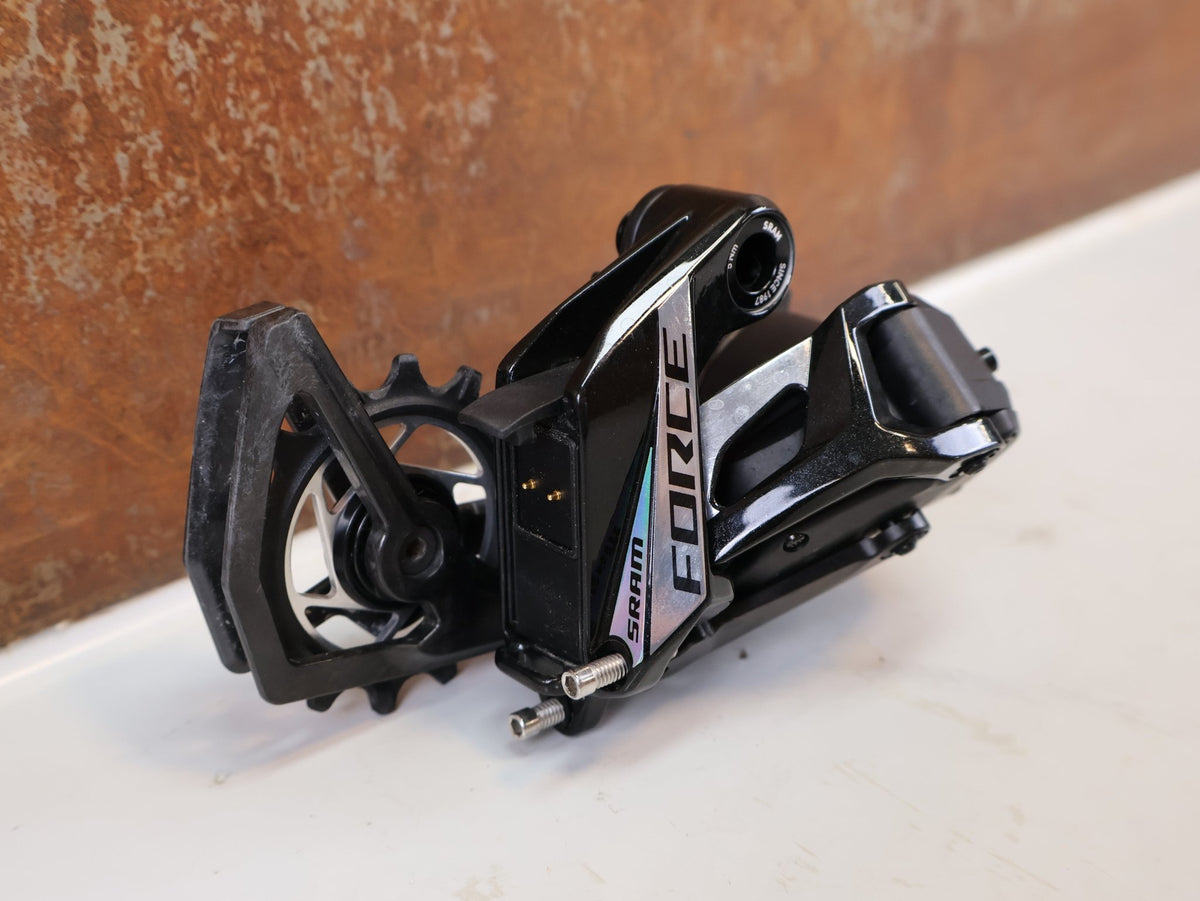 Schaltungsteile von Sram, SRAM Force AXS E1 Schaltwerk 12-fach 36T Max Carbon vor USEDBIKES-OB.DE Hintergrund