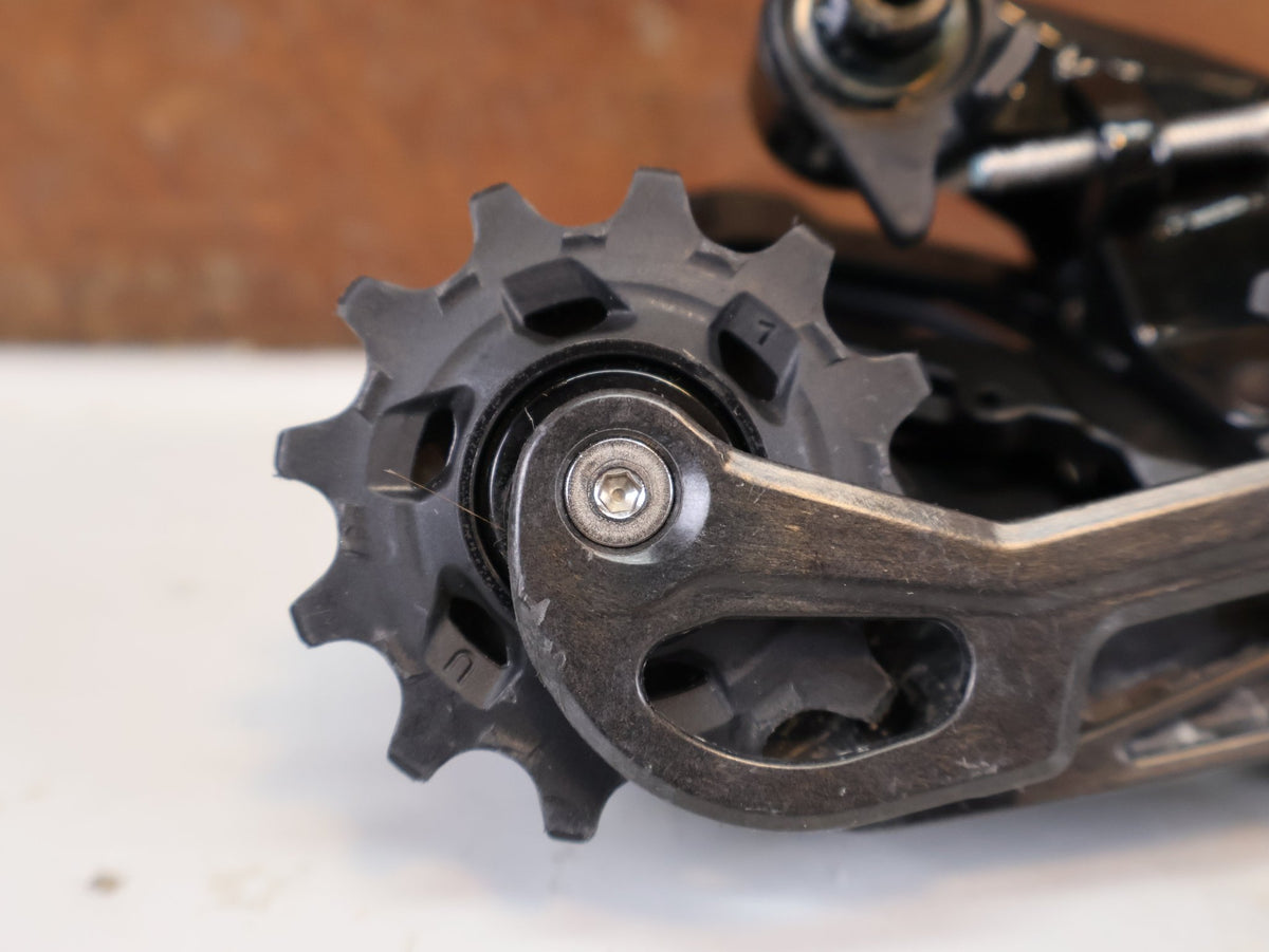 Schaltungsteile von Sram, SRAM Force AXS E1 Schaltwerk 12-fach 36T Max Carbon vor USEDBIKES-OB.DE Hintergrund