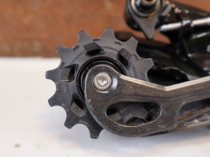 Schaltungsteile von Sram, SRAM Force AXS E1 Schaltwerk 12-fach 36T Max Carbon vor USEDBIKES-OB.DE Hintergrund