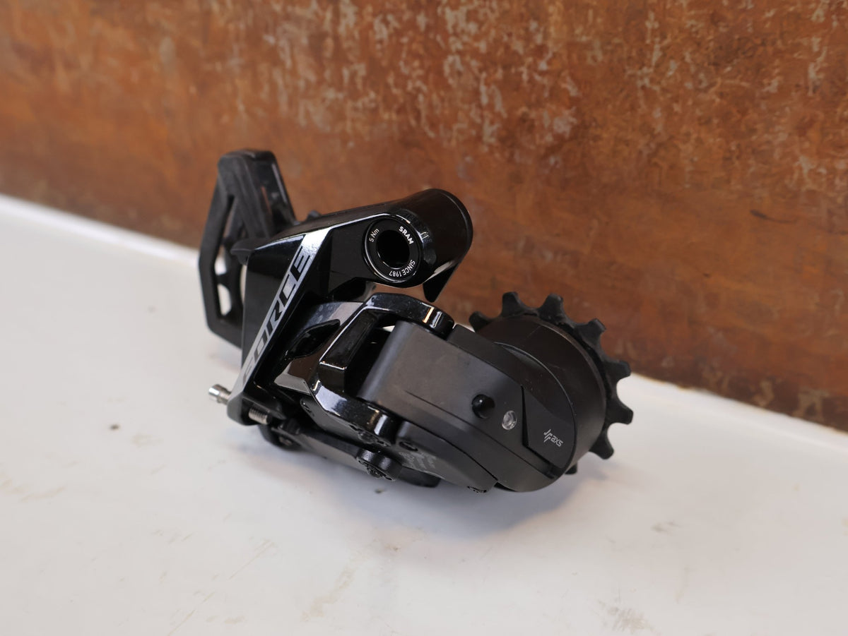 Schaltungsteile von Sram, SRAM Force AXS E1 Schaltwerk 12-fach 36T Max Carbon vor USEDBIKES-OB.DE Hintergrund