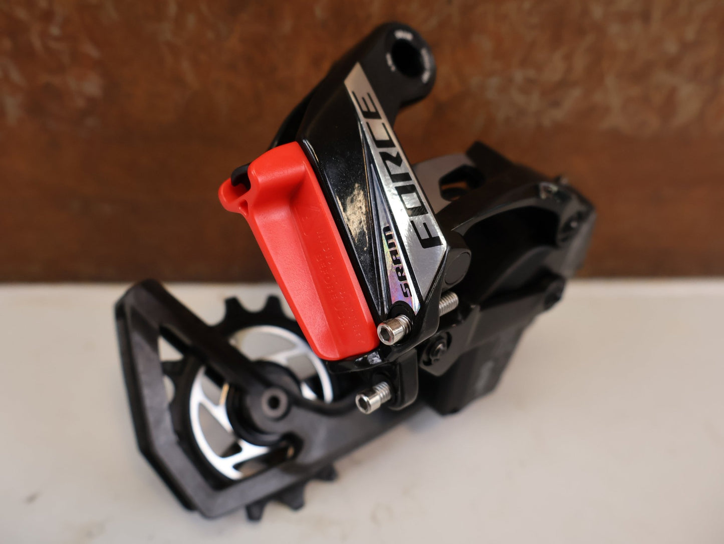 Schaltungsteile von Sram, SRAM FORCE AXS SCHALTWERK 12-FACH 36T E1 CARBON vor USEDBIKES-OB.DE Hintergrund