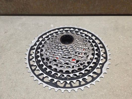 Kassette & Zahnkränze von Sram, SRAM FORCE AXS XPLR XG 1371 KASSETTE 13 FACH 10 - 46 ZÄHNE vor USEDBIKES - OB.DE Hintergrund