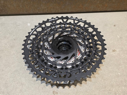 Kassette & Zahnkränze von Sram, SRAM FORCE AXS XPLR XG 1371 KASSETTE 13 FACH 10 - 46 ZÄHNE vor USEDBIKES - OB.DE Hintergrund