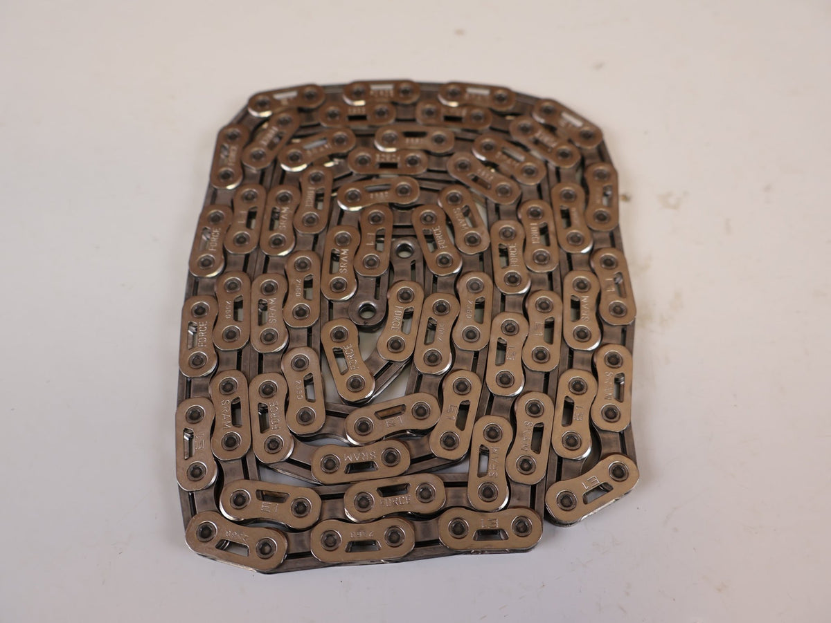 Kette von Sram, SRAM FORCE E1 KETTE FLATTOP 12 / 13 FACH SILBER 114 GL vor USEDBIKES-OB.DE Hintergrund