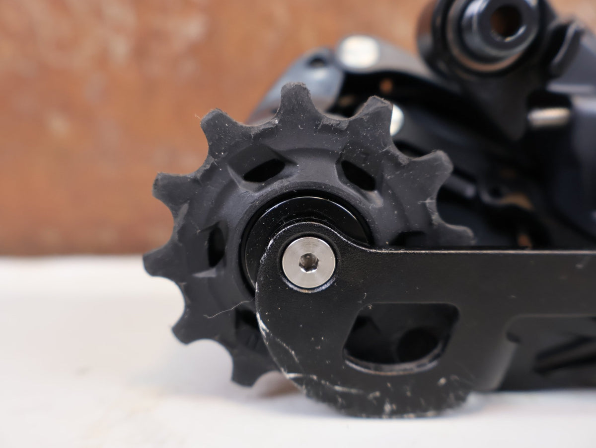 Schaltungsteile von Sram, SRAM Force eTap AXS D1 Schaltwerk 12-fach Short Cage 33T vor USEDBIKES-OB.DE Hintergrund