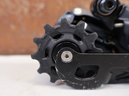 Schaltungsteile von Sram, SRAM Force eTap AXS D1 Schaltwerk 12-fach Short Cage 33T vor USEDBIKES-OB.DE Hintergrund