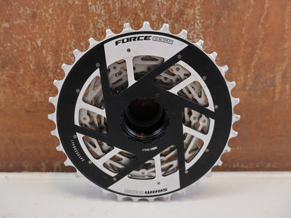 Kassette & Zahnkränze von Sram, SRAM FORCE XG-1270 E1 KASSETTE 12-FACH 10-33T vor USEDBIKES-OB.DE Hintergrund